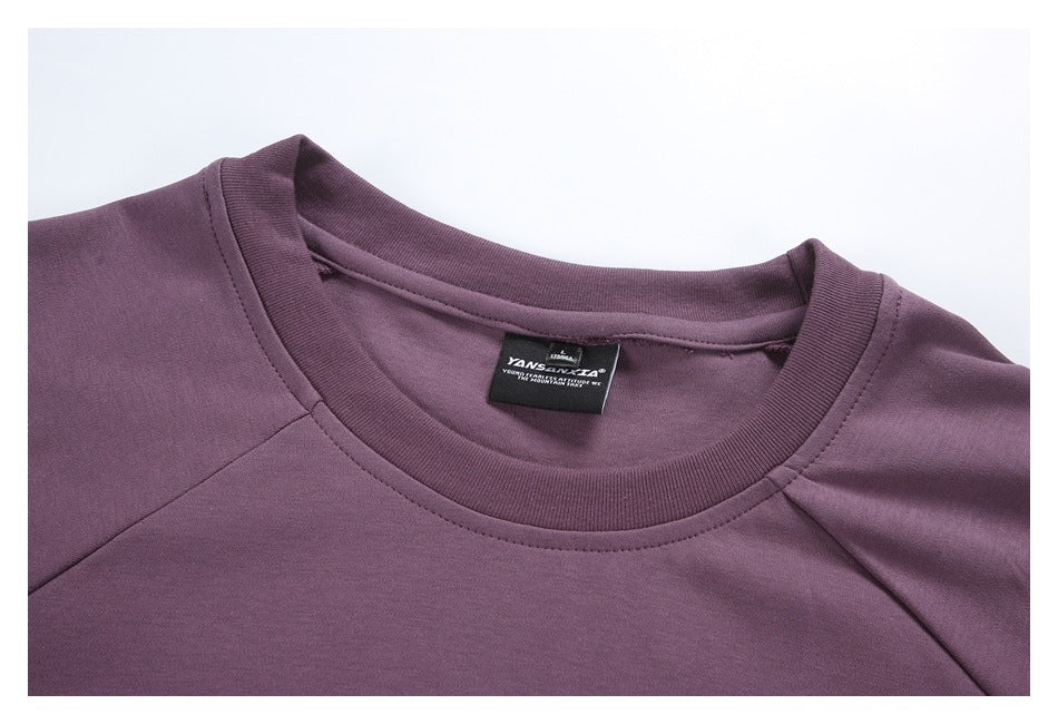 Close-up of the plum top's crew neckline, raglan seams and inner label.