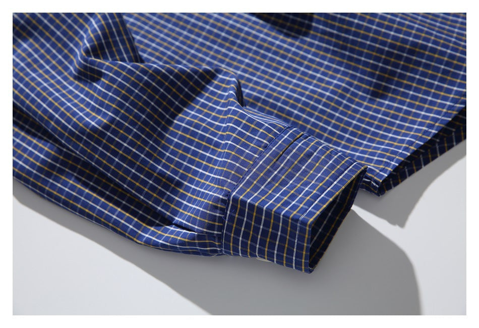 Close-up of the blue plaid shirt sleeve and buttonless cuff laid flat.