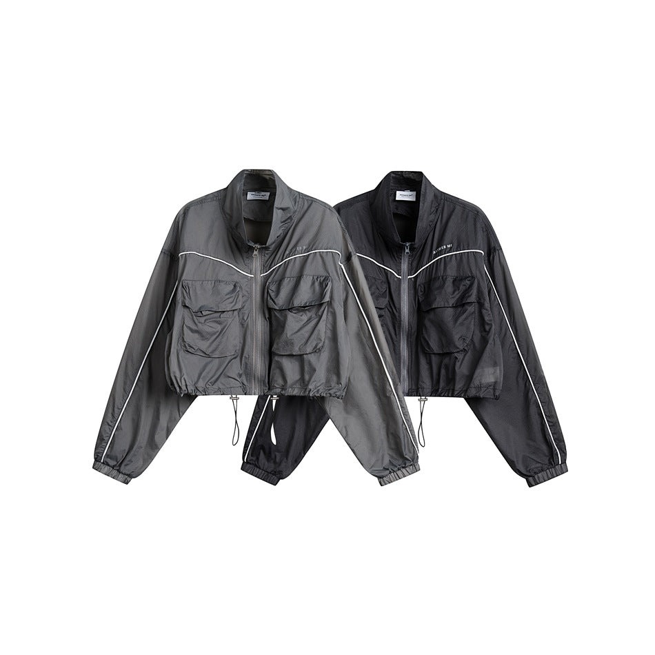 Two cropped zip jackets displayed together in gray and black, each with white piping and flap pockets.