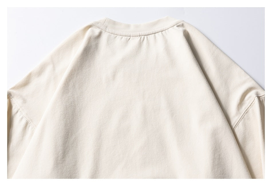 Close-up of the plain ivory sweatshirt back, showing the ribbed crew neckline and shoulder seams.