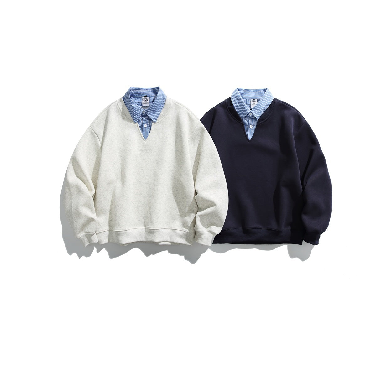 Two front-facing sweatshirts with striped shirt collars: light heather gray and dark navy.