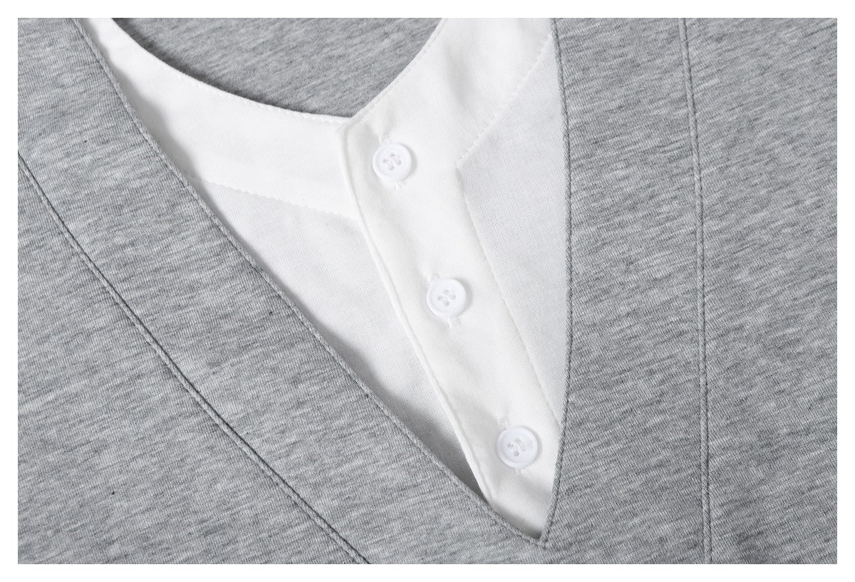 Close-up of three white buttons on the inner placket framed by the gray V-neck trim.
