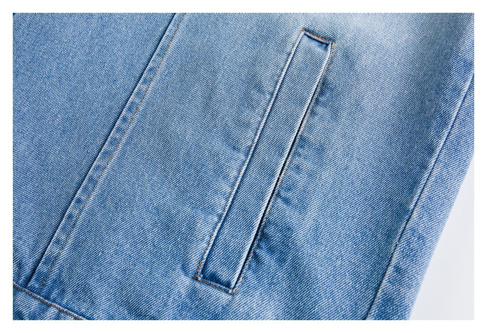 Close-up of a narrow vertical welt pocket and stitched seams on blue denim.