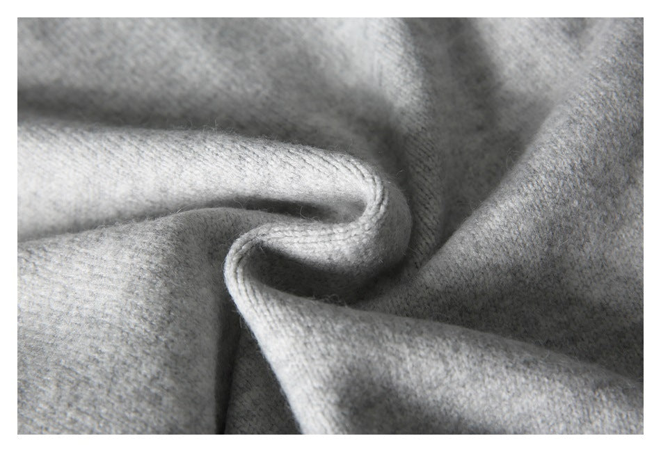 Close-up showing the soft-looking light gray knit texture and folded edge of a sweater.