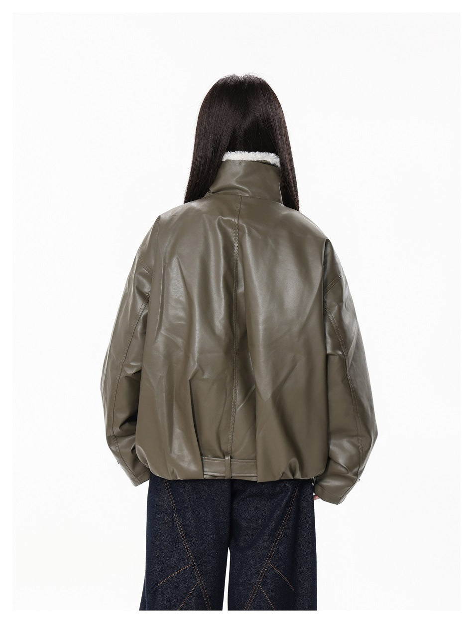 Rear view of a person wearing an oversized olive-gray jacket with a high fleece-lined collar and dark trousers.