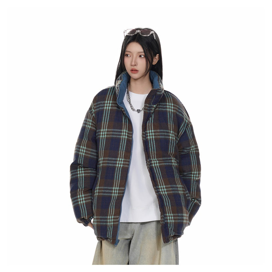 Model wearing an oversized navy and brown plaid jacket with turquoise stripes, open over a white top, front view.