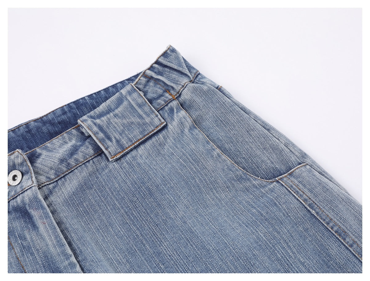 Close-up of faded blue jeans showing a belt loop, waistband, and front pocket stitching.