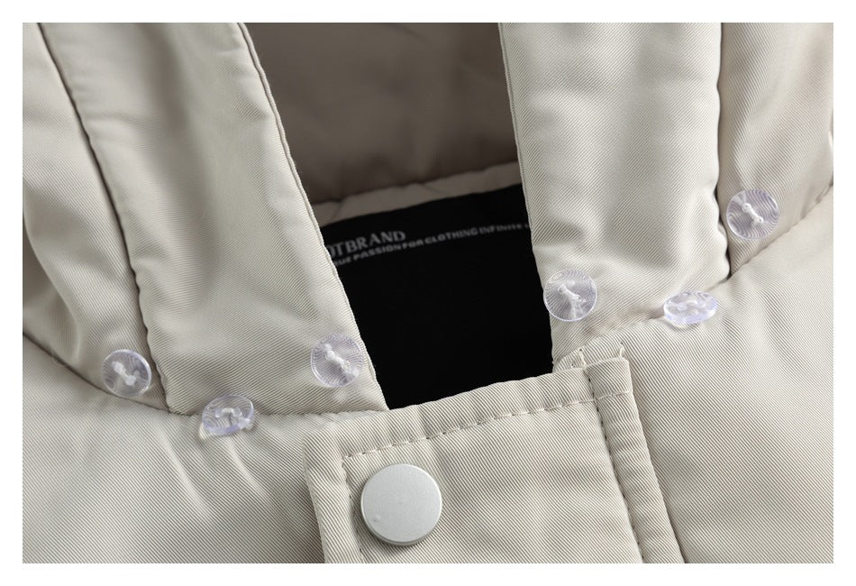 Close-up of an ivory garment’s hood opening, clear snap fasteners, and front closure.