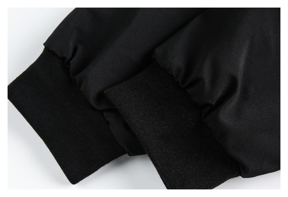 Close-up of a black garment with two wide ribbed knit bands at the edges of the fabric.