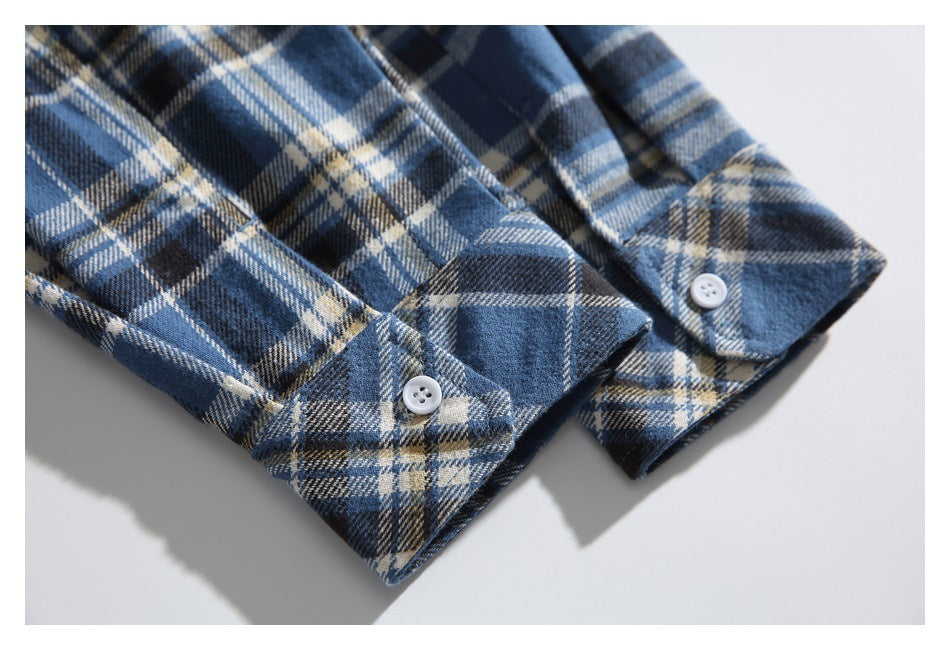 Close-up of blue plaid shirt cuffs with white buttons.