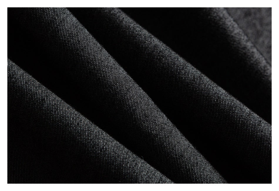 Macro view of the dark charcoal fabric with a fine diagonal weave and soft folds.