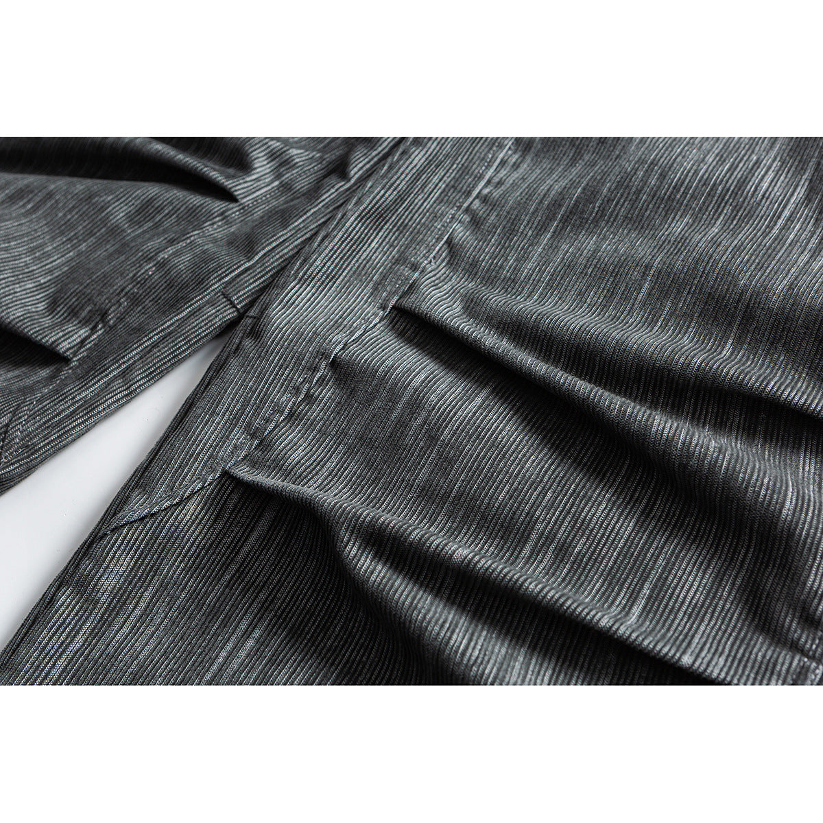 Close-up of gray trousers showing the textured fabric, stitching, and a folded seam.