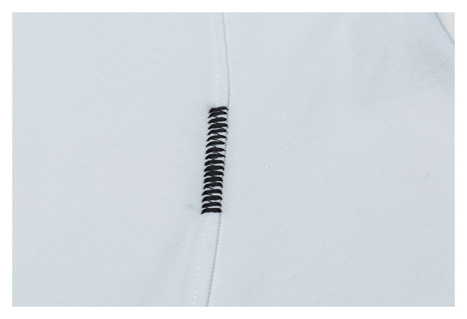 Close-up of white fabric with a narrow black decorative stitch along a seam.