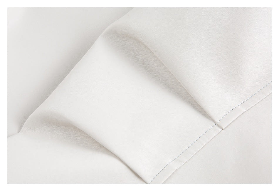 Close-up of white garment fabric with a folded edge and pale blue stitching.