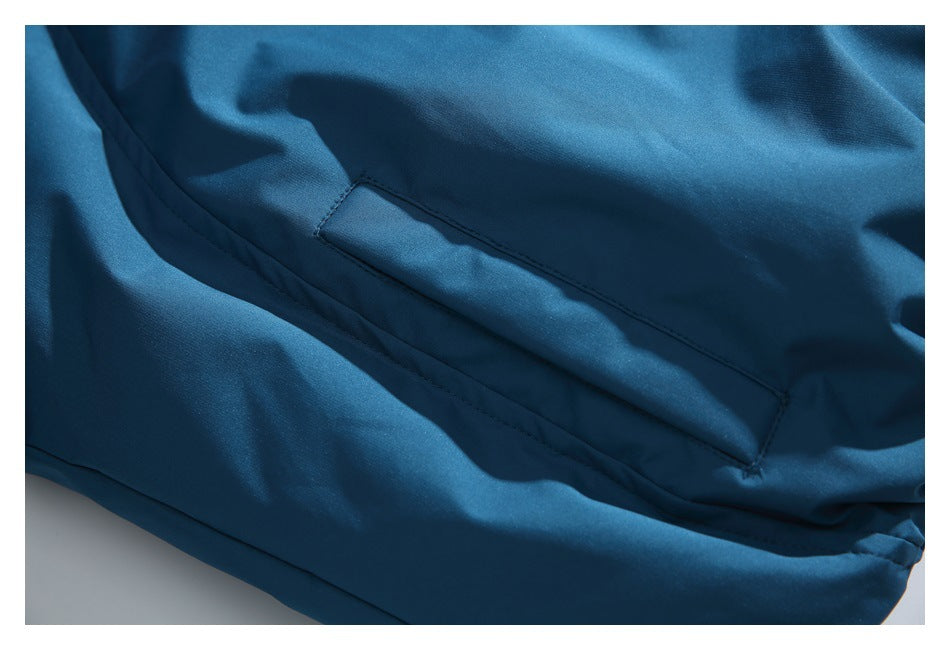 Close-up of a blue jacket with a long stitched pocket opening.