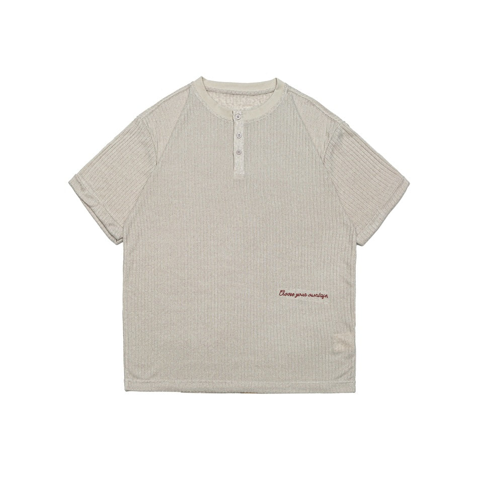 Beige ribbed knit Henley short-sleeve top, front flat lay, with three buttons and small red script embroidery