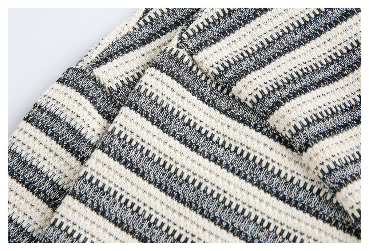 Close-up of a seam in a black and ivory striped knit garment, showing the textured stitching.