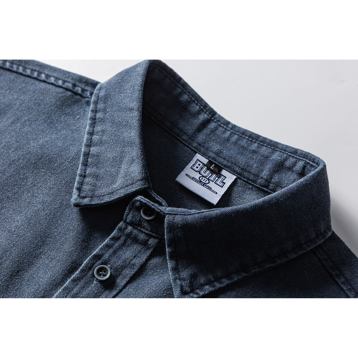 Close-up of a dark blue short-sleeve shirt collar, buttons, and inner neck label.