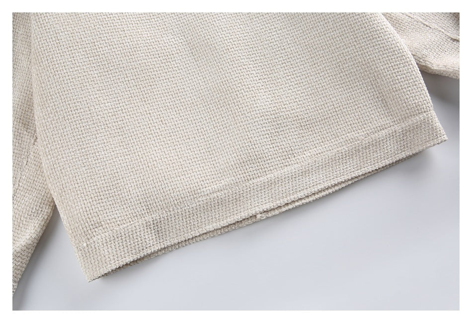Close-up of the finished hem on a cream textured woven garment.