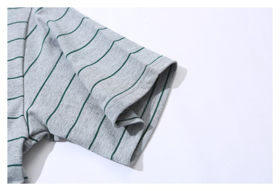 Close-up of the short sleeve and hem of a gray T-shirt with narrow green stripes.