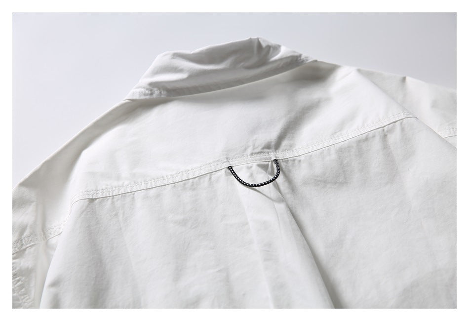 Close-up of a white shirt's back yoke with a small dark hanging loop at the center.