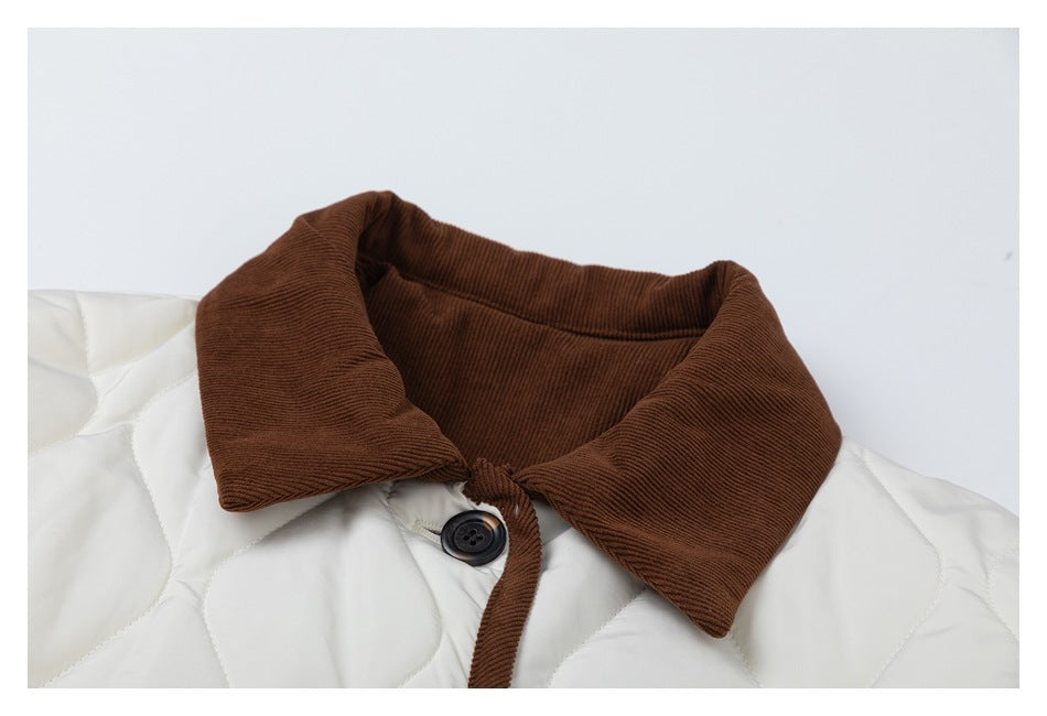 Close-up of the jacket's brown corduroy collar and a dark button on ivory quilted fabric.