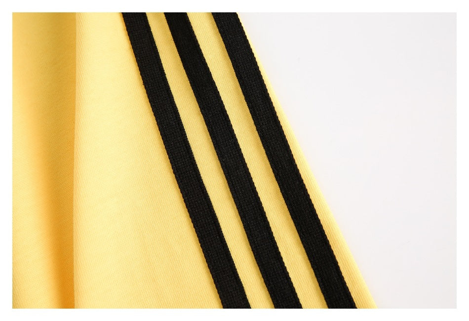 Close-up of three parallel black stripes on yellow fabric.