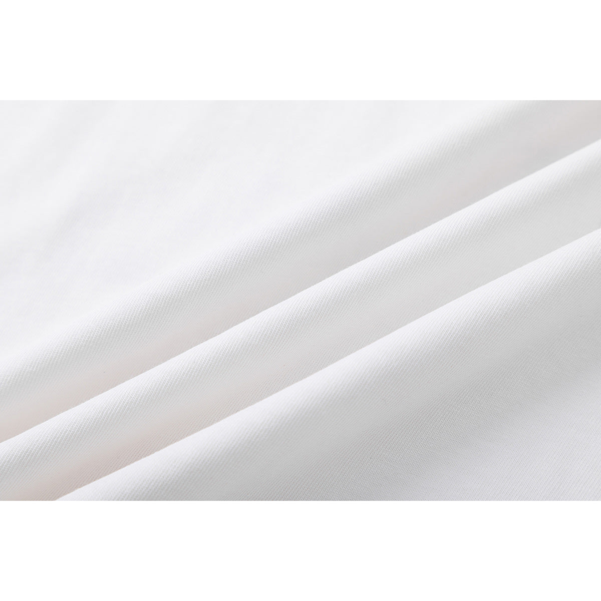 Close-up of white T-shirt fabric arranged in soft folds.