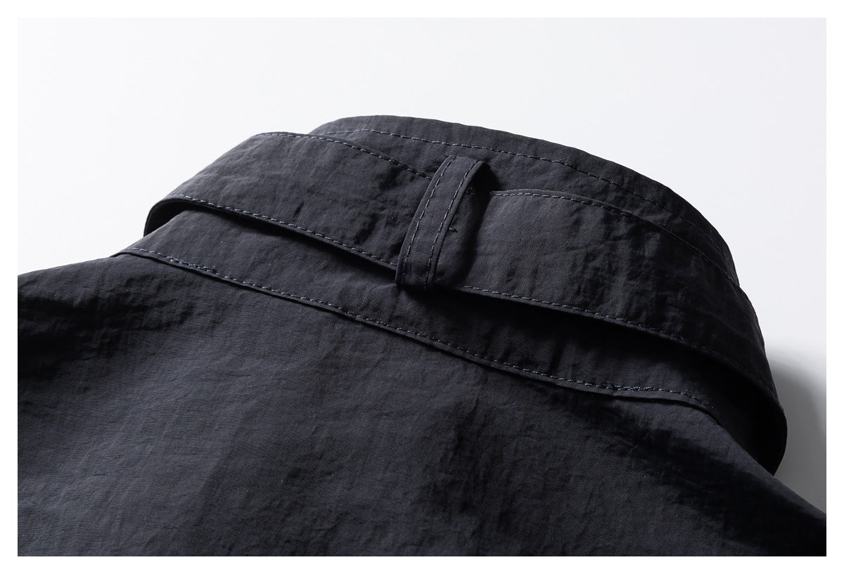 Close-up of a dark garment's stitched band and narrow fabric loop.