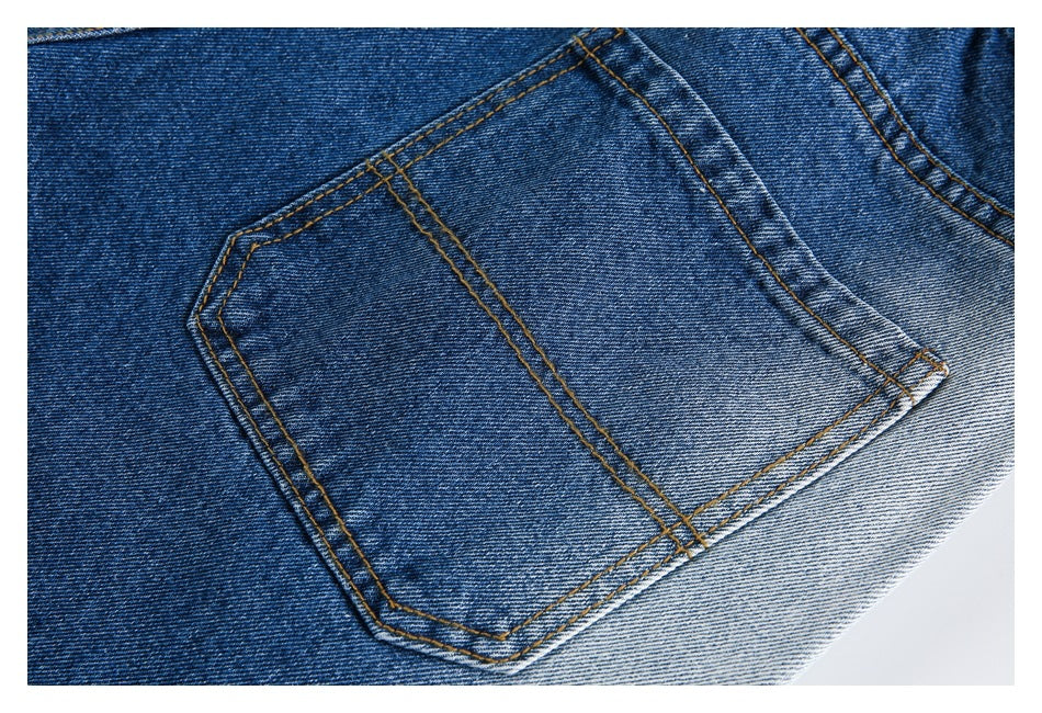 Close-up of a blue denim back pocket with contrasting golden-brown stitching.