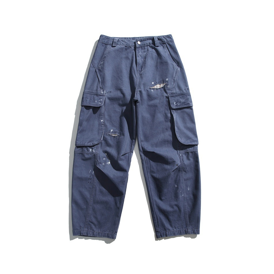 Navy blue distressed cargo pants with large side flap pockets and paint splatter, flat lay front view