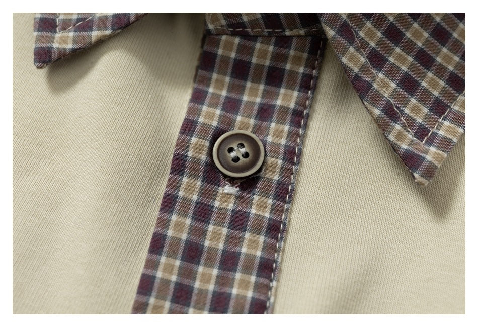 Close-up of a cream shirt collar and placket with a brown, burgundy, and tan plaid insert and dark button.