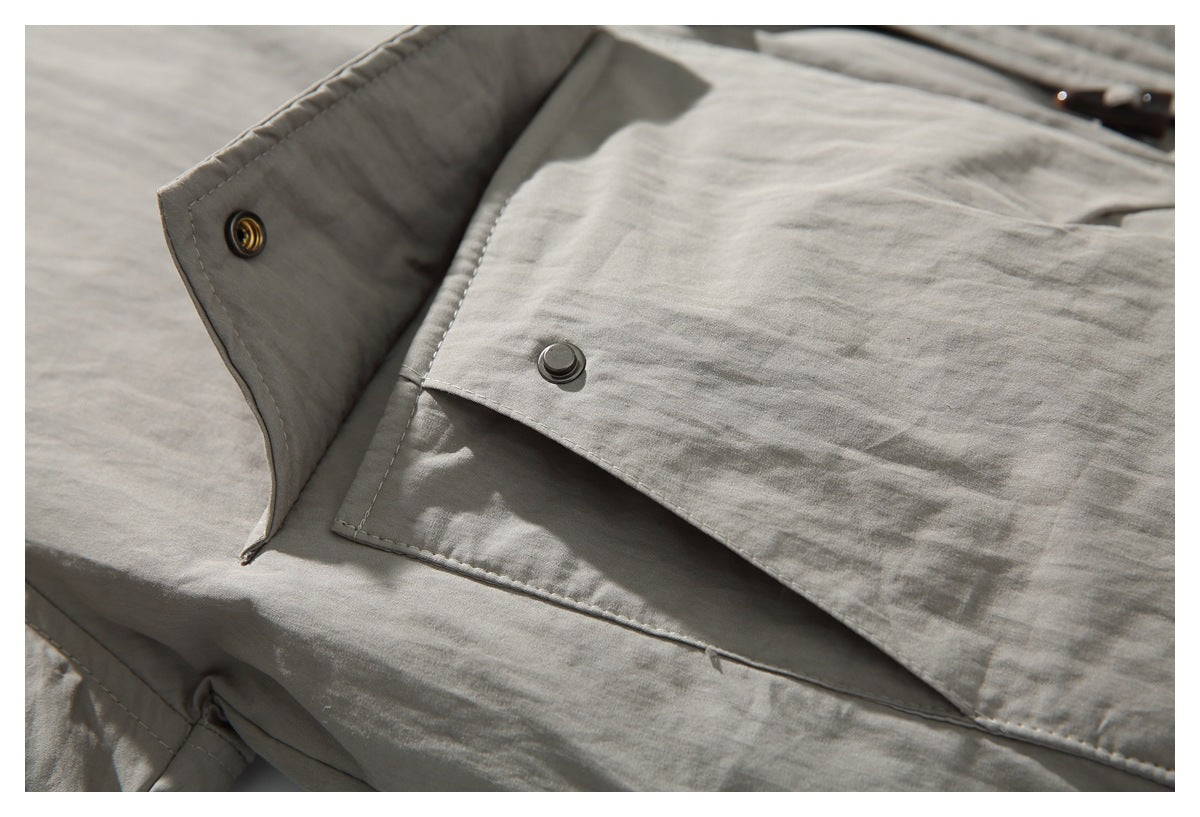 Close-up of the taupe jacket's front flap and snap fastener, with the collar edge open.