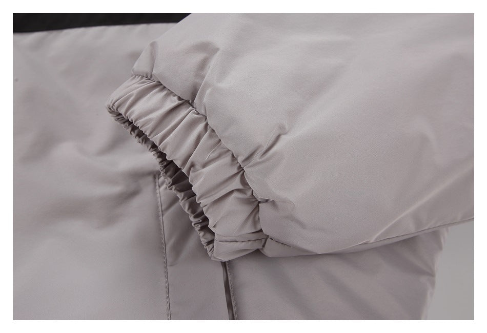 Close-up of a gathered elastic cuff on the light gray garment sleeve.