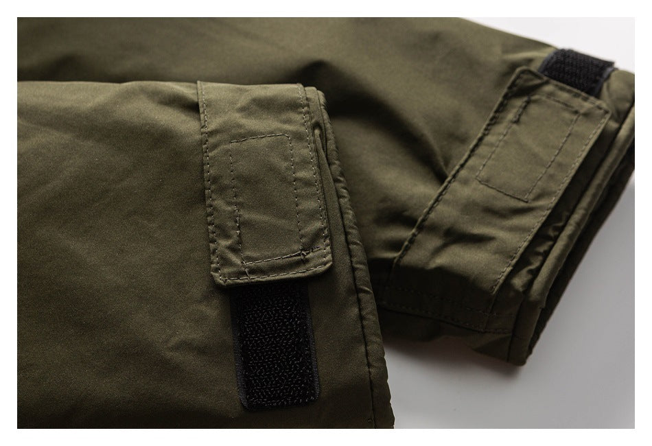 Close-up of olive jacket sleeve cuffs with black hook-and-loop adjustment tabs.