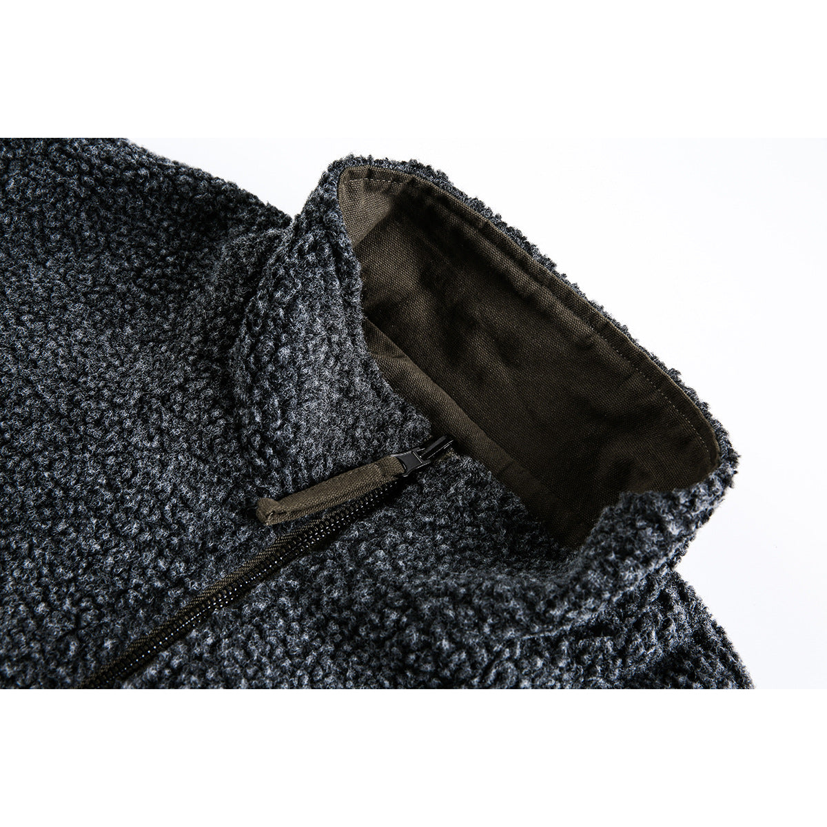 Close-up of a charcoal textured jacket collar, dark lining, and zipper pull.