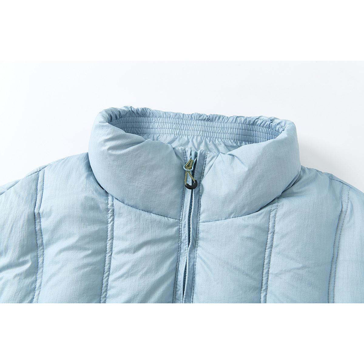 Close-up of a pale blue puffer jacket's tall collar, front zipper, and stitched panels.
