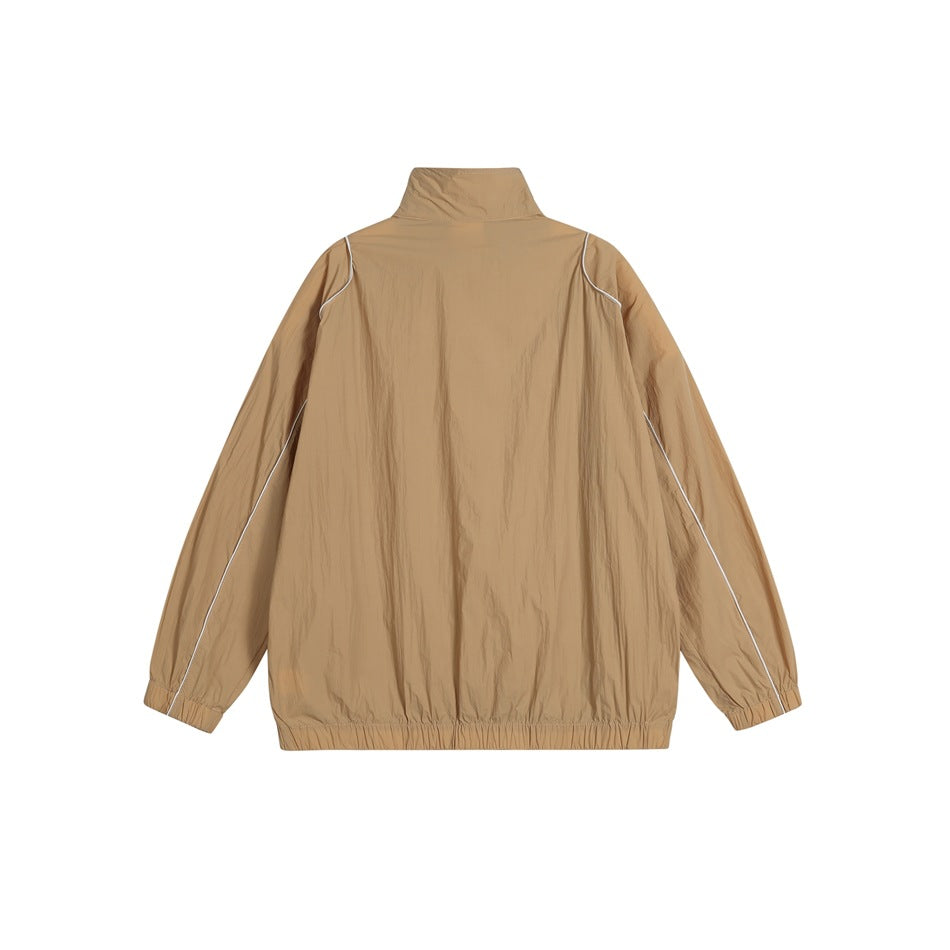 Back view of a tan zip-up jacket with a high collar, elastic cuffs and hem, and white piping.