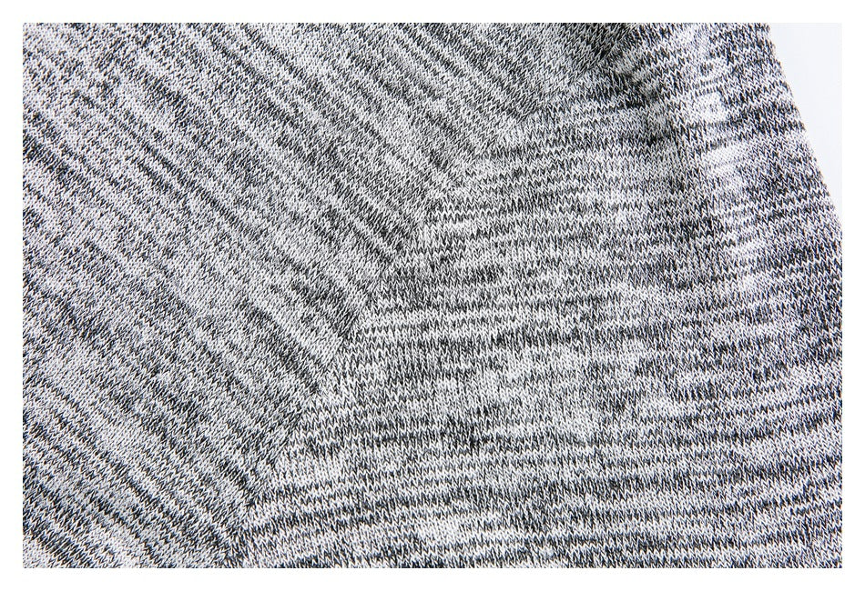 Close-up of the garment's black, gray, and white marled knit texture.