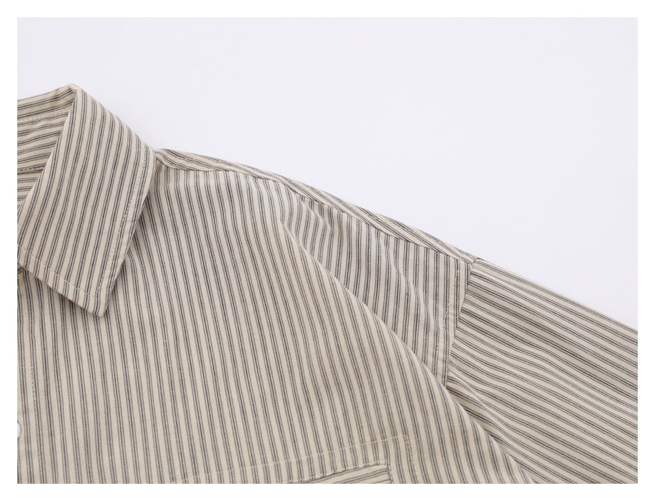 Close-up of the striped shirt's shoulder, collar edge, and short sleeve seam.