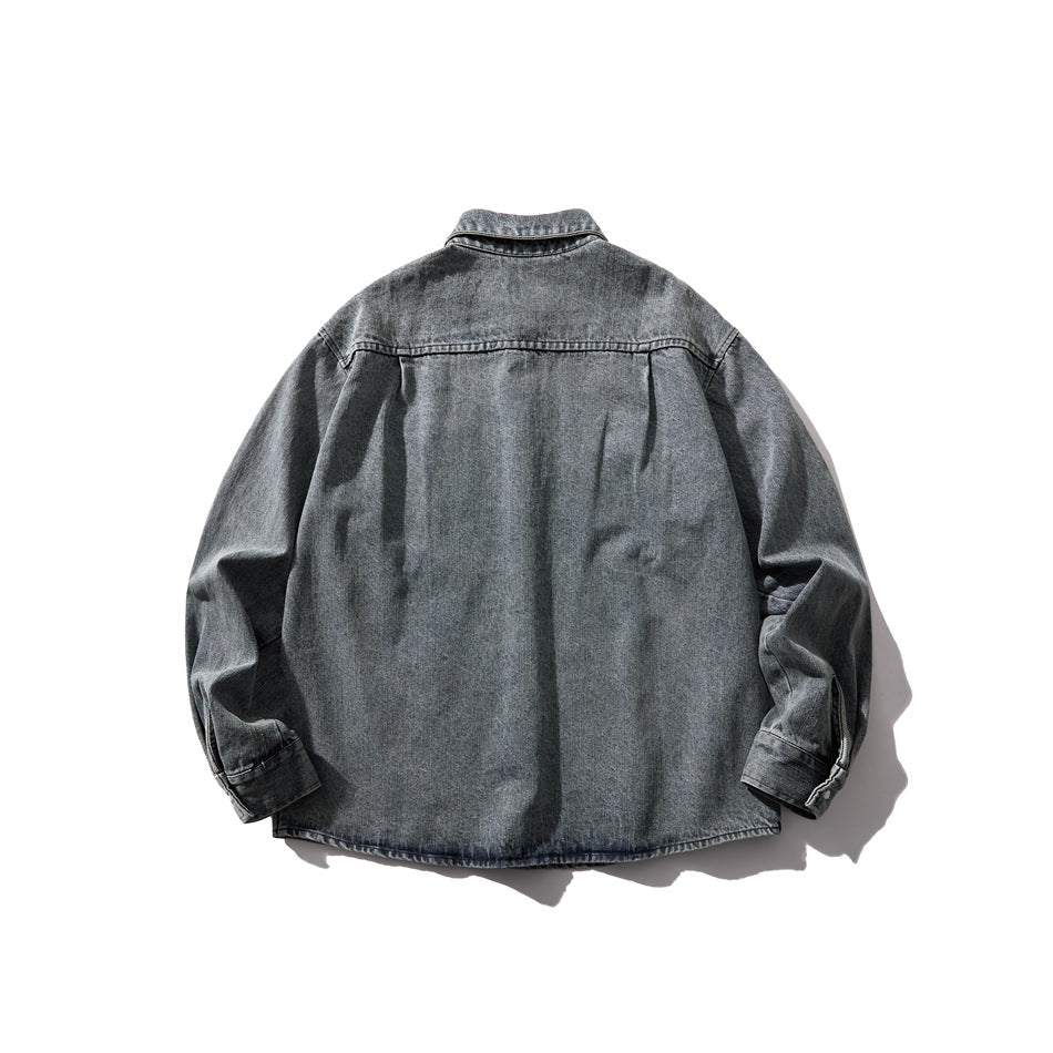 Back view of washed gray-blue denim shirt laid flat showing yoke seam and long sleeves