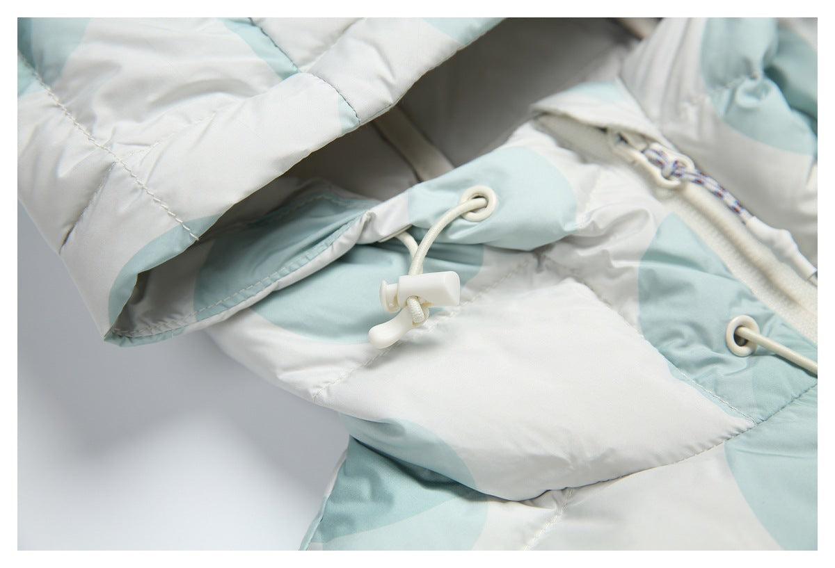 Close-up of the jacket hood edge and white drawcord toggle against the pale aqua and white print.