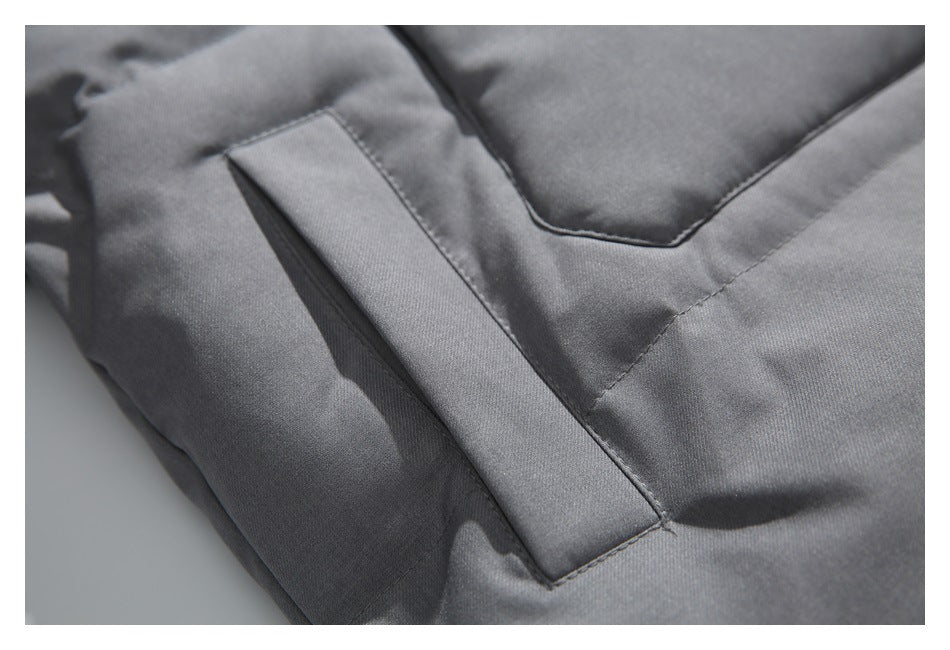 Close-up of a gray jacket's angled pocket opening and stitched panels.