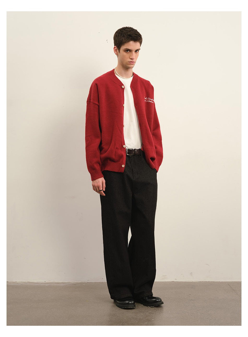 Model wearing a red button-front cardigan with white chest embroidery, a white shirt, and black wide-leg trousers.