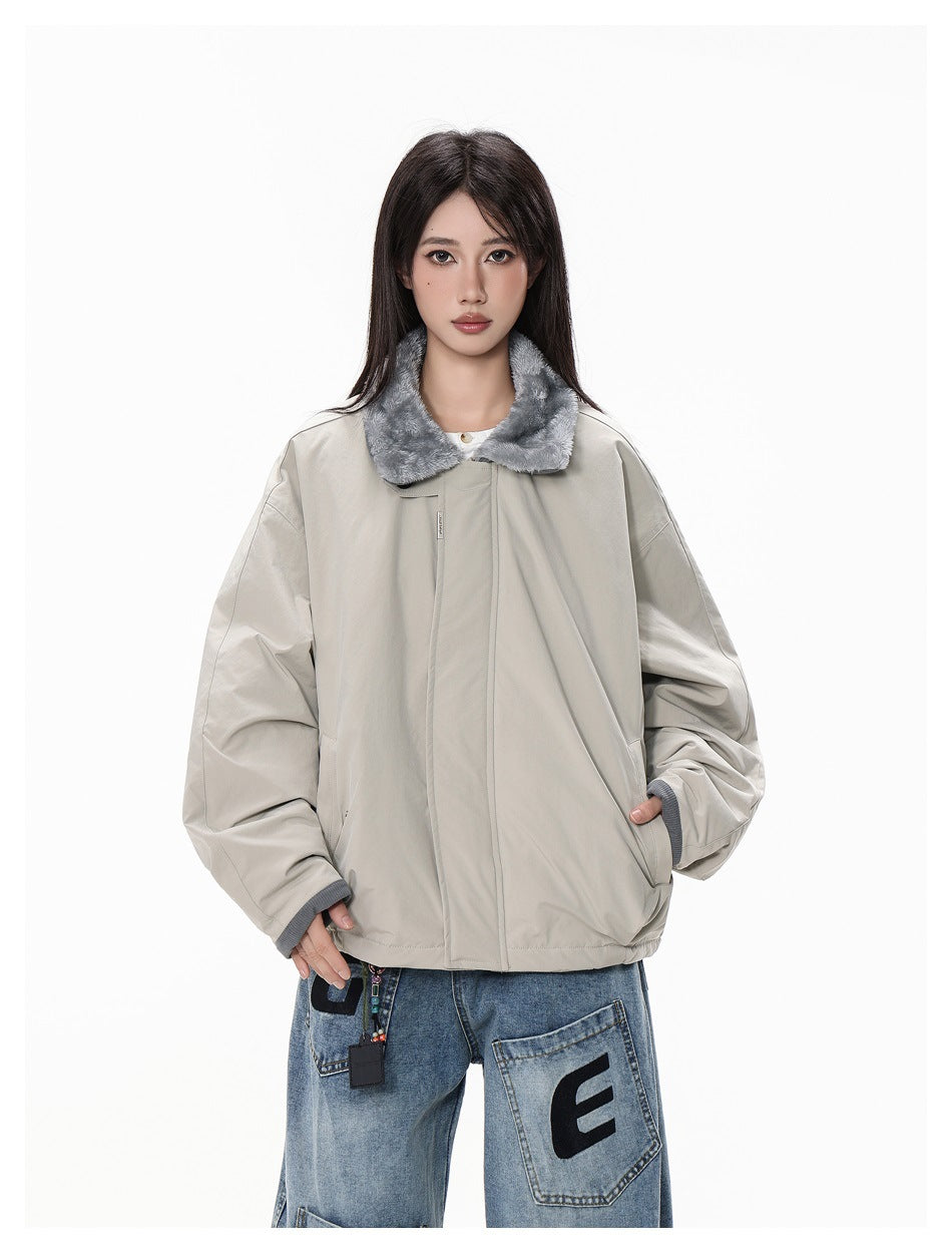 Model wearing an oversized light gray jacket with a plush gray collar and front closure.