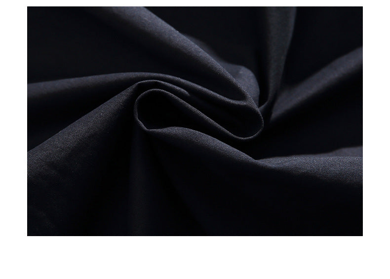 Close-up of dark fabric draped into folds, showing its smooth surface.