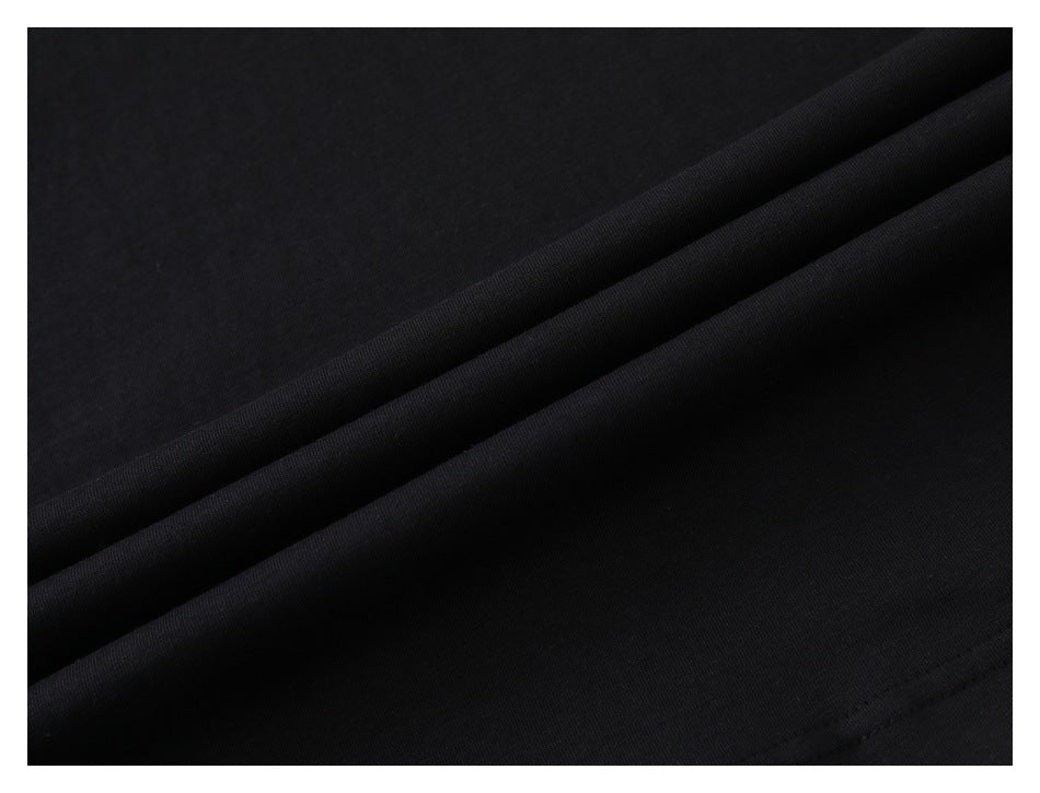 Close-up of smooth black fabric draped in diagonal folds.
