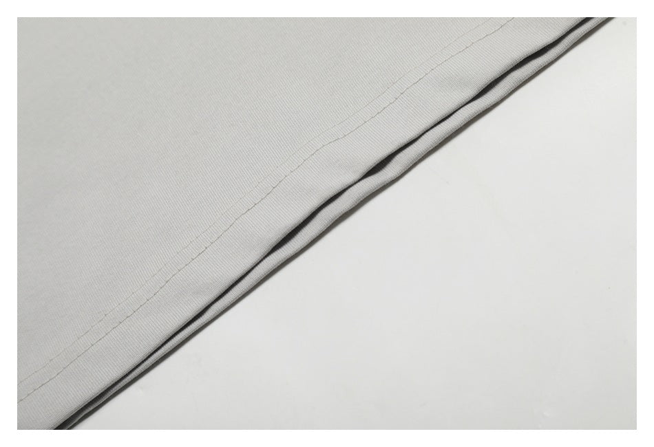 Close-up of the light gray shirt’s double-stitched bottom hem.