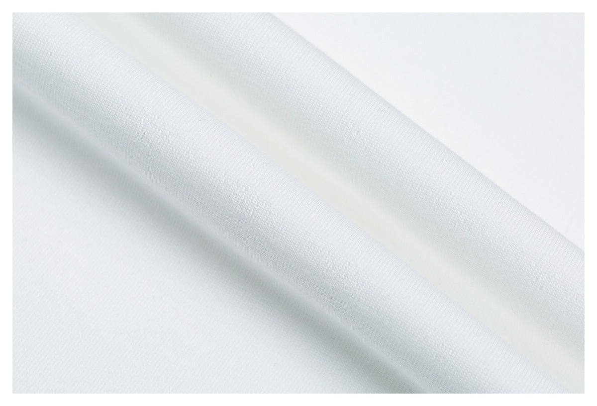 Close-up showing the fine surface texture and soft folds of white garment fabric.