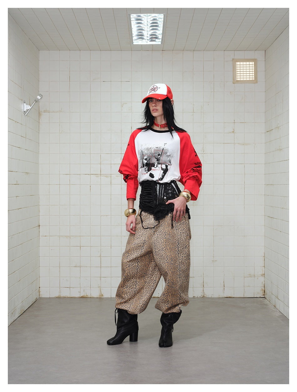 Front view of a model in a white graphic raglan shirt with red sleeves, styled with a black corset and leopard-print